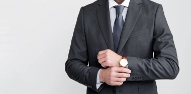 mature ceo wear businesslike suit check time on watch on grey background.