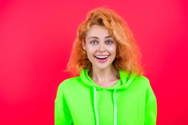 Sıradan bir yaşam tarzı. Havalı kapüşonlu giyen kızıl saçlı kız. Pembe üzerine izole edilmiş şık bir kadın. Hareketli moda kız kapüşonlu giyer. Moda kıyafetleri ve tarzı. Kazaklı beyaz bir kadın. Moda modeli.