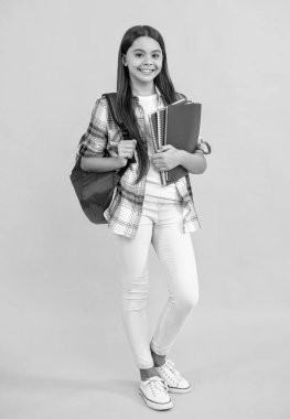 Arka planda tam boy liseli kız var. Sırt çantalı liseli kızın fotoğrafı. Genç liseli kız sarıda izole edilmiş. Stüdyodaki genç kız..