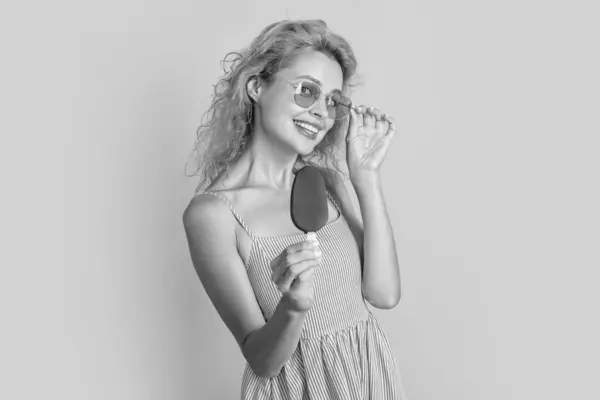 stock image positive woman with icecream in studio. woman with icecream on background. photo of woman with icecream at summer. woman with icecream isolated on yellow.