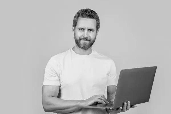 stock image happy man blogger in studio. photo of man blogger with laptop. man blogger isolated on yellow. man blogger on background.