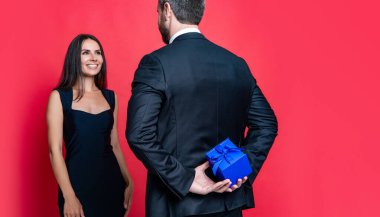 Hediyeli romantik evlenme teklifi. Hediye. Erkek kadına evlenme teklif ediyor. Erkek, sevgililer günü için kadınlara hediye kutusu verir. Sevgililer günün kutlu olsun. Aşık çift kırmızıda izole edilmiş. Eşsiz öneri.