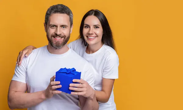 stock image Loving woman giving present for Valentines day. Gift box to surprised man. Boyfriend receiving present from girlfriend. Valentines day couple. Couple in love. Mans day gift. Beautifully wrapped.