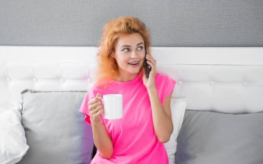 Kahveli mutlu kadın telefonda konuşuyor. Telefonla konuşan bir kadın. Kadının evinde telefon görüşmesi..