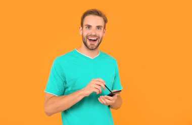 Modern iletişim teknolojisi olarak blog yazma. Blog yazarı akıllı telefon ve stil kullanır. İnternette çalışan adam. Dijital kalemle resim yapmak. memnun adam dijital kalemle grafik tasarımı çizer.