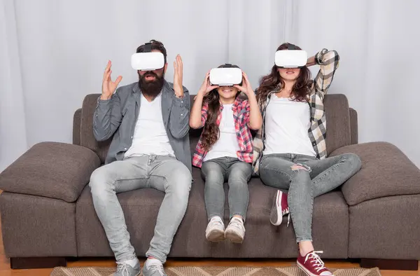 stock image digital future and innovation. modern life. father mother and child wireless VR glasses. virtual reality family. amazed parents with kid girl use modern technology. mom dad and daughter.