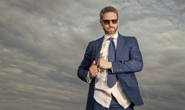 Takım elbiseli zengin adam, kopyalama uzayı. Paralı bir adamın zengin fotoğrafı. Gökyüzü geçmişinde parası olan zengin bir adam. Parası olan zengin bir adam..