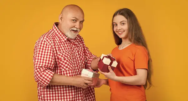 stock image smiling child and grandfather with present box for anniversary.