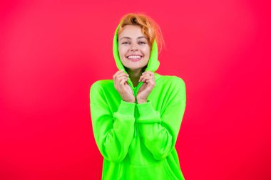 Sıradan kapüşonlu, şık, beyaz bir kadın. Modayla ilgilenen kız modaya uygun ve parlak görünüyor. Pembe kapüşonlu bir kadın. Moda modeli. Şık kapüşonlu kızıl saçlı kız. Rahat sofistike.