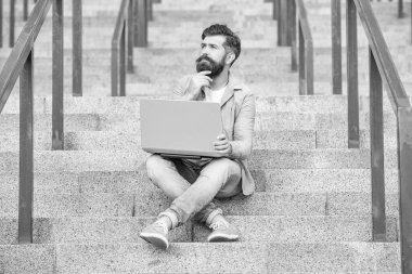 Düşünen adamın dışarıda online video iletişimi var. Adamın dışarıda çevrimiçi video bağlantısı var. Adamın merdivenlerde online video bağlantısı var. Adamın dizüstü bilgisayarında video bağlantısı var..