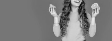 Mutlu genç kız pembe arka planda portakal meyvesi tutuyor..