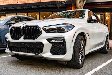 New York City, ABD - 15 Mart 2024: BMW X6 modern beyaz araba, köşedeki manzara.
