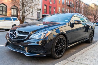 New York City, ABD - 15 Mart 2024: 2014 Mercedes Benz E550 lüks araba, köşedeki manzara.