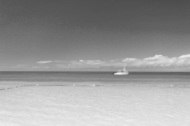 Mavi suda yaz tatili yatı. Deniz kenarında yaz tatili yatı. Yaz tatilinde deniz kenarında yat gezisi. Plajda yaz tatili yatının fotoğrafı..