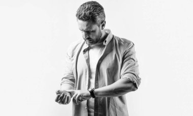 Nabız ölçen bir adam. Bileğinde nabzı atan olgun bir adam. Gri arka planda izole edilmiş bilek nabzını kontrol et. Stüdyoda nabzı kontrol eden bir adam var..