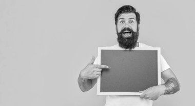 Sakallı adam sarı pankartta izole edilmiş bir ilan veriyor. Adam arka planda fotokopi alanı olan bir reklam sunuyor. Adam stüdyoda reklam veriyor. Bir adamın fotoğrafı tahtaya reklam veriyor.