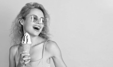 Yazın dondurma yiyen kadın, fotokopi uzayı. Külahta dondurması olan kadın sarıda izole edilmiş. Stüdyoda dondurmalı bir kadın var. Arka planda dondurma külahlı kadın.