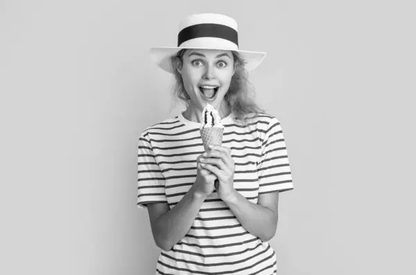 stock image summer woman eat sweet cone in studio. summer woman with sweet cone on background. photo of summer woman with sweet cone in retro hat. summer woman with sweet cone isolated on yellow.