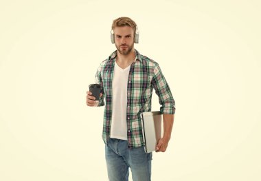 Bin yıllık erkek öğrenci arka planda kahve tutuyor. Stüdyoda bin yıllık öğrenci. Dizüstü bilgisayarlı bin yıllık bir öğrencinin fotoğrafı. Bin yıllık erkek öğrenci beyazlar içinde izole edilmiş..