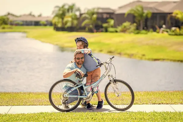 stock image active father setting a example for fathers son. fathers parenting with son outdoor. childhood of son supported by fathers care. father and son on bicycle at fathers day. Dad and kid adventures.