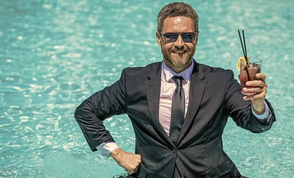Businessman successful deal. Successful project. Businessman i in swimming pool. business man on summer vacation. Business success man outdoor. Businessman in suit drink cocktail in pool. cheers.