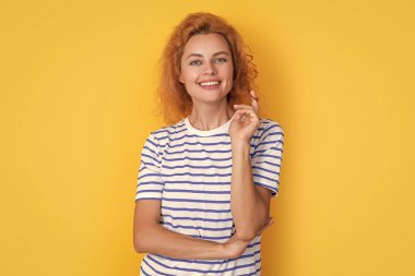 Sarı arka planda izole edilmiş mutlu kızıl saçlı kadın portresi. Stüdyodaki genç kızıl saçlı kadının portresi. Yetişkin kızıl kadın portresi.