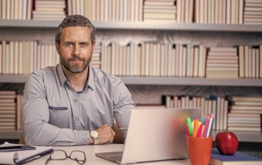 Okulda öğretmenle çevrimiçi eğitim almak sınıfta dizüstü bilgisayarla..