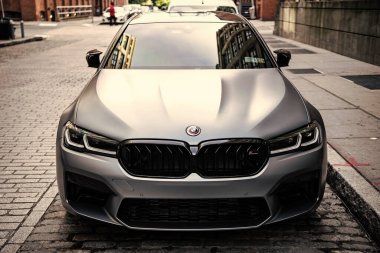 New York, ABD - 15 Temmuz 2023: BMW F90 M5 gri renkli araba park edilmiş, ön manzara.