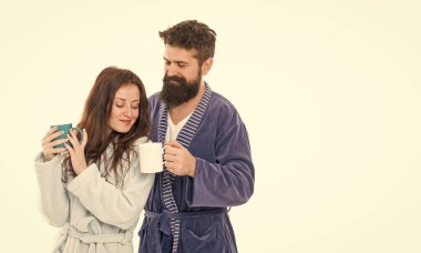 Man and woman wear bathrobes hold tea mug or coffee cup. Caffeine power concept. With coffee morning tastes better. Couple relax in morning with coffee. Couple enjoy lazy weekend and drink coffee.