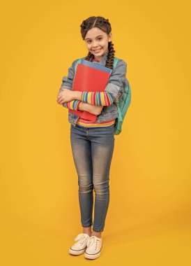 Happy pupil yellow background. Teenage pupil holding books. Pupil back to school. September 1. Knowledge day.