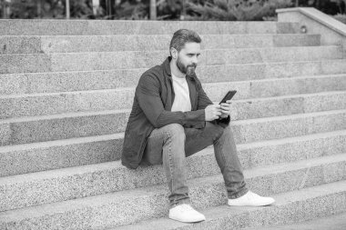 Elinde telefonla mesajlaşan bir adamın görüntüsü. Adam dışarıda telefonla mesajlaşıyor. Adam sokakta telefonla mesajlaşıyor. Telefondaki adam dışarıda mesaj atıyor..