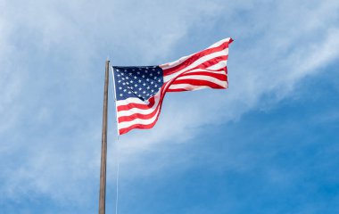 Vatanseverlik sembolü. Anma Günü için Amerikan Bayrağı ya da 4 Temmuz. Rüzgarda dalgalanan Amerikan bayrağı. ABD bayrağı. Mavi gökyüzünde Birleşik Devletler bayrağı sallıyor. Bağımsızlık Günü. Bağımsızlık.