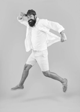 Stüdyoda acele eden sakallı adam ne mutlu. Sakallı adam arka planda acele ediyor. Sakallı adamın yaz modası giydiği bir fotoğraf. Acele eden sakallı adam sarıda tek başına..