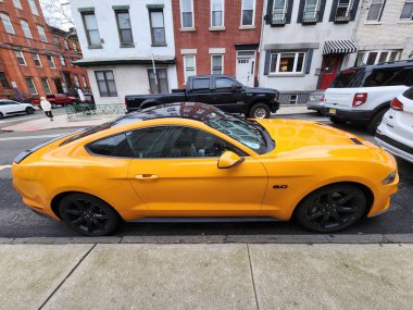New York City, ABD - 10 Mart 2024: 2018 Ford Mustang sarı spor araba, yan görüş.