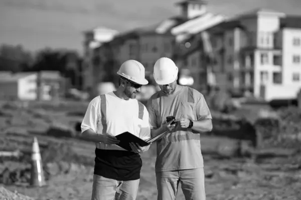 architect men with construction project. architect men with construction project. architect men discussing construction project outdoor. architect men have construction project on clipboard.