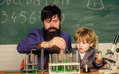 Laboratuvar deney tüpleri ve renkli sıvılarla dolu mataralar sakallı adam öğretmen ve küçük çocuk. Kimya deney tüpü. baba ve oğul okulda. Laboratuvar araştırma ve geliştirme. Yenilik.