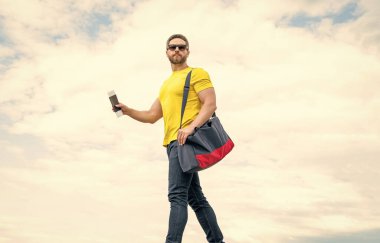 Seyahat çantası ve belgeyle seyahat eden insan. Gökyüzü arkaplanı, tatil.