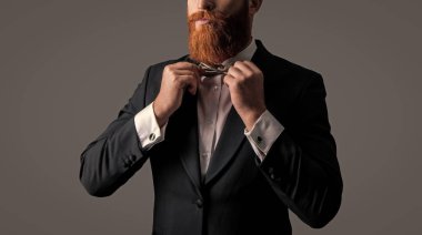 Sakallı bir adam papyon atölyesini düzeltiyor, gri sakallı. Smokinli, uzun sakallı, sakalsız bir erkek..