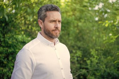 Beyaz gömlekli yakışıklı profesyonel adam. Doğal arka plan, kopyalama alanı..