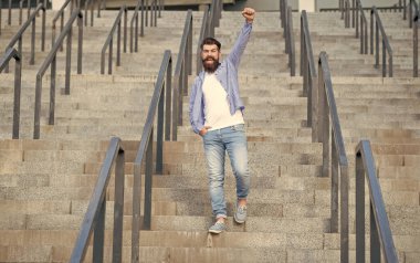 Mutlu sakallı adam aşağıya iniyor. Uzun boylu, sakallı bir adam. Merdivenlerdeki hippi çocuk..