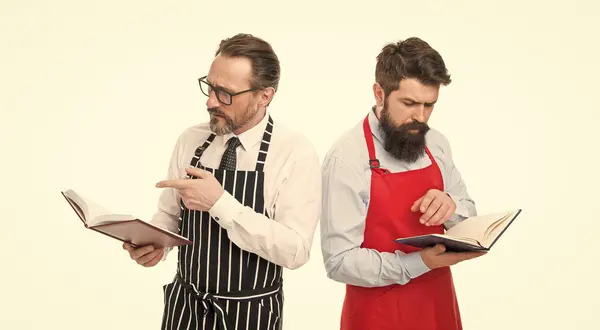 making notes. cafe and restaurant opening. menu planning. happy chef team in apron. catering business. seating plan. partners cook cooking. Culinary ingredient. bearded men with recipe book, notes.