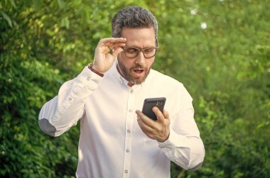 Hayret verici iş analisti açık havada telefonla çalışıyor. İnternette çalışan iş analisti. İnternette çalışan iş analistinin fotoğrafı. İş analisti online çalışıyor.