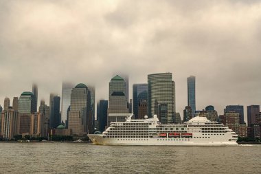New York 'tan Manhattan' a giden bir sonraki yolcu gemisi. New York Manhattan 'ın silueti Hudson Nehri yolcu gemisiyle geziyor. Yolcu gemisinde tatil