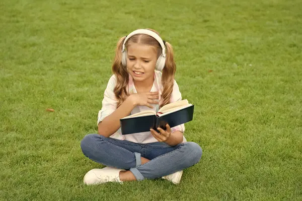 Genç kız yaşam tarzı. Gençler kitaptan hoşlanmaz. Park yerinde rahatla. müzik eğitimi dinlerken. Açık havada genç bir kızın yaşam tarzı. Müzik kulaklıklı genç kız. kendi kendine okuma kitabı yoluyla eğitim.