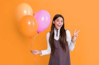 girl with party colorful balloons on yellow background. peace.