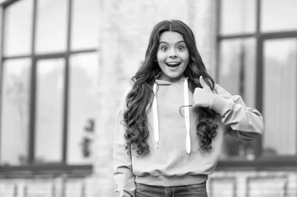 Surprised Teenage Girl Casual Hoodie Giving Thumb Gesture Blurry Outdoors lizenzfreie Stockbilder