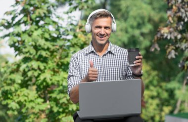 cheerful businessman in headphones. businessman freelancing. mature businessman listen audio book.