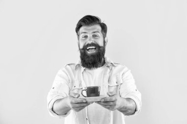 Mutlu beyaz adam gülümsüyor bir fincan sıcak içecek sarı arka plan, çay.