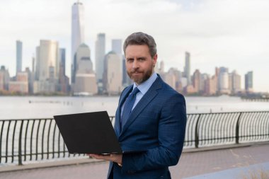 New York 'ta serbest çalışan bir iş adamı. İnternette çalışan bir iş adamı. İş adamı dışarıda bilgisayar ya da dizüstü bilgisayarda çalışmakla meşgul. Adam internet tarayıcısından iş e-postası ve sörf yolluyor. Piyasa talebi.