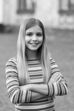 Çocukluğunda gülümseyen sarışın kız. Genç kız çocukluğunu dışarıda geçirdi. Genç bir kızın çocukluk fotoğrafı. Genç kız çocukluğu.